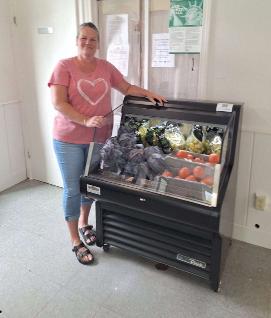 Person standing next to produce display case.